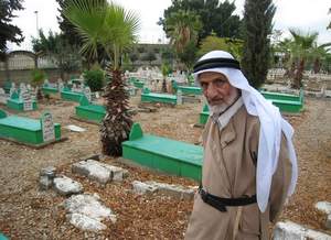 Mohammed Arabi, 84, a survivor of the Kafr Qassem massacre, stands by the graves of the 47 villagers killed by Israeli police in 1956. Jonathan Cook / The National 